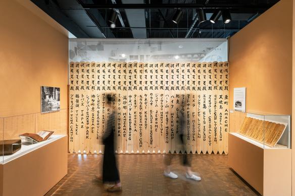 photo of two people in motion, they are standing in a gallery surrounded by artifacts. They are blurry and facing away from one another
